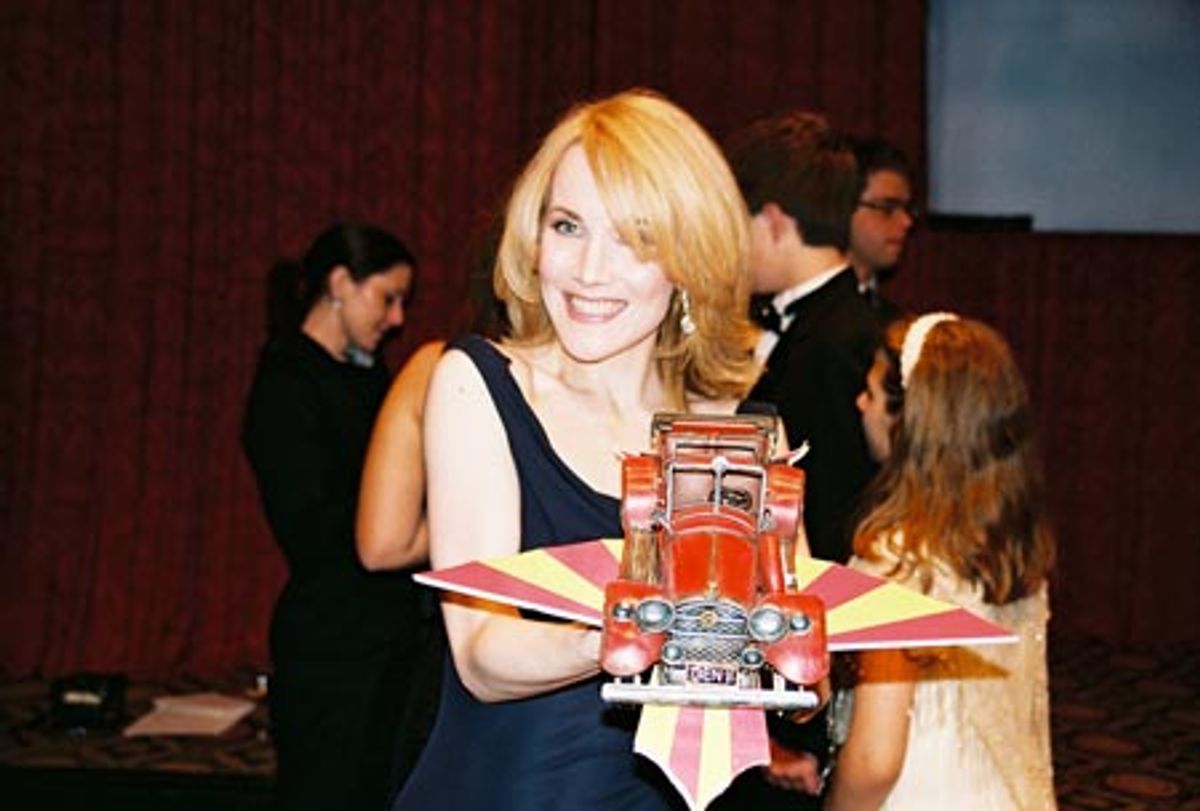 Erin Dilly holding up a model of the Chitty car  at 