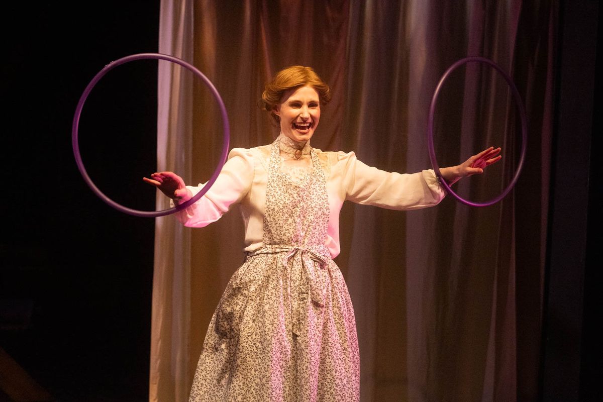 In this still, Meg March (Amy Rene Byrne) represents her trouble making current jam by twirling two hoolah hoops on her wrists. This retelling of Little Women makes it ambiguous whether we are witness