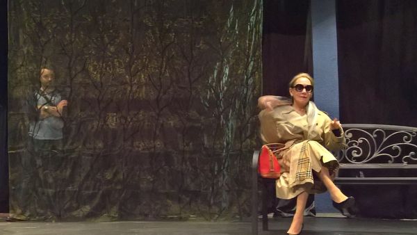 Rehearsal photo of Alex Fox (Seth) peering at his mother through the trees as she sits on her park bench. Anna, a woman of secrets - are they real?
Photo by Don Horn 1