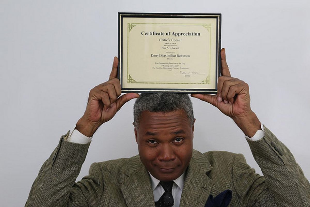 DELIGHTED TO WIN AN AWARD FOR DIRECTING "GODOT"!: Excaliber Shakespeare Company of Chicago and Excaliber Shakespeare Company Los Angeles Archival Project Founder Darryl Maximilian Robinson displays his 1998 WKKC Radio Chicago Critic's Corner Fine Arts Award for Outstanding Director Of The Play "Waiting For Godot" presented in 1997 by The Excaliber Shakespeare Company of Chicago at The Heartland Cafe Studio Theatre in Chicago, Illinois.  2016 photo of Darryl Maximilian Robinson in his awards room by J. L. Watt.