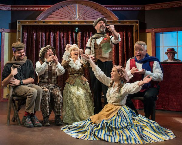 The cast of Christmas at the Old Bull and Bush in the Cratchit family scene. A British Music Hall entertainment with song and dance, silly jokes and sentimental  favorites and, of course, Christmas crackers. 2