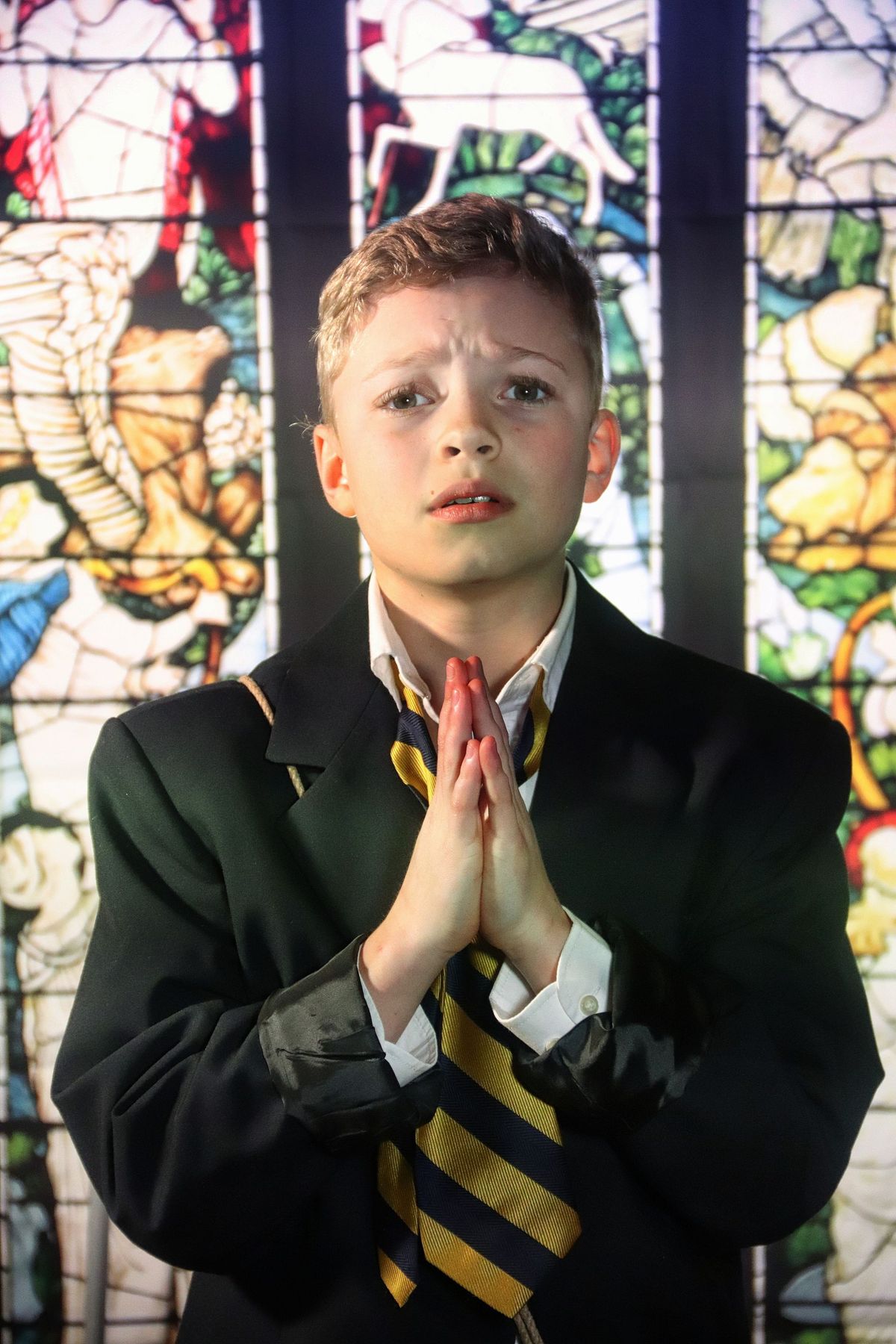 Tommy Murphy (Jack Wolf) praying that his dad bring home Fish and Chips and Mushy Peas.  
Photo Credit: Kate Murray Studios