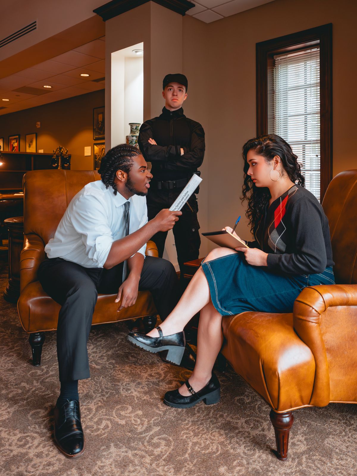 (L to R): Trevor Hudson (Calvin), Jonah Uffelman (Nikolas/The Guard), and Victoria Martinez (Ensemble/Swing) for Antigone 1989: A Town Hall Musical. Photo by Geovanny Soto.