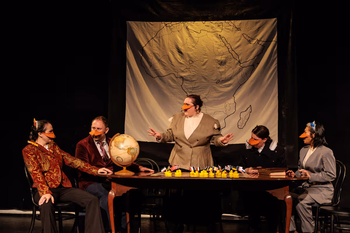 King Leopold II (Allison McCall), Baron de Crested (Ryland Garnett), the Marquês de Penaquill (Hollie Pryor), Sir Mallard (Madison Shmalo) and De Eend (Chris Say) meet as delegates of the Berlin Conference of 1884 in Heart of Duckness by A.J. Ditty. Photo by Kat Moraros Photography. King Leopold II (Allison McCall), Baron de Crested (Ryland Garnett), the Marquês de Penaquill (Hollie Pryor), Sir Mallard (Madison Shmalo) and De Eend (Chris Say) meet as delegates of the Berlin Conference of 1884 in Heart of Duckness by A.J. Ditty. Photo by Kat Moraros Photography.