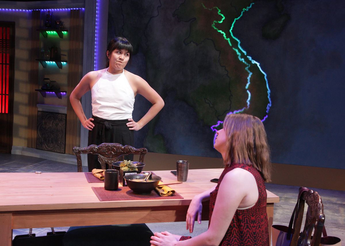 Hannah Mariah as Danielle and Chloe Gay Brewer as Julie in the rolling world premiere of "Colonialism is Terrible, But Phở is Delicious," playing March 31 - April 30, 2023 at Better Aitken theater arts Center on the Cripe Stage. Written by Dustin H. Chinn; Directed by Oánh Nguyễn. Photo by Doug Catiller, True Image Studio. 