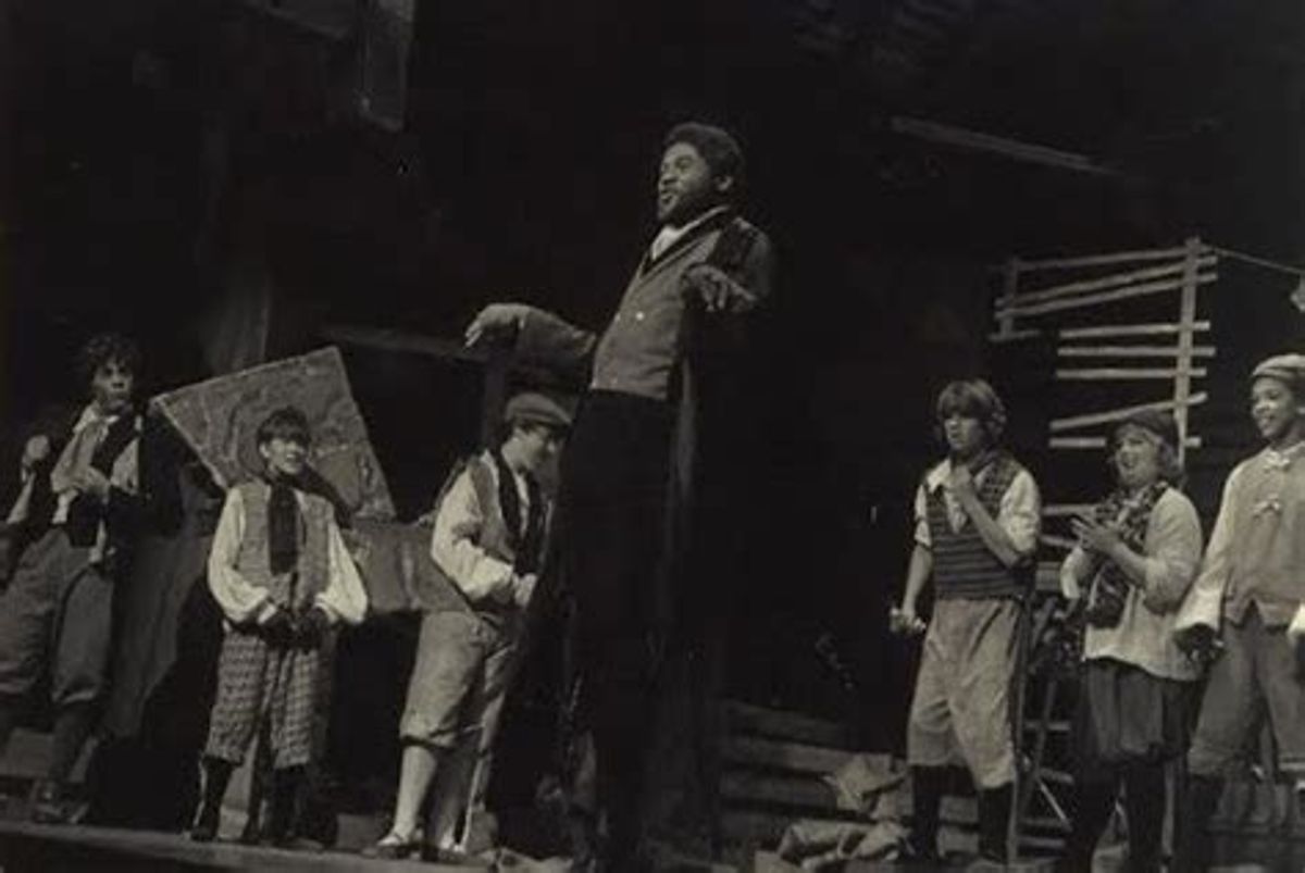 AN AWARD-WINNING VILLAIN!: Chicago-born stage actor and play director Darryl Maximilian Robinson ( seen at center ) as Fagin in the Enchanted Hills Playhouse of Syracuse, Indiana revival of Lionel Bart's classic musical "Oliver!" is winner of the 1981 Fort Wayne News-Sentinel Reviewer's Recognition Award for Outstanding Thespian of the Season for his first season of roles at The EHP. AN AWARD-WINNING VILLAIN!: Chicago-born stage actor and play director Darryl Maximilian Robinson ( seen at center ) as Fagin in the Enchanted Hills Playhouse of Syracuse, Indiana revival of Lionel Bart's classic musical "Oliver!" is winner of the 1981 Fort Wayne News-Sentinel Reviewer's Recognition Award for Outstanding Thespian of the Season for his first season of roles at The EHP.