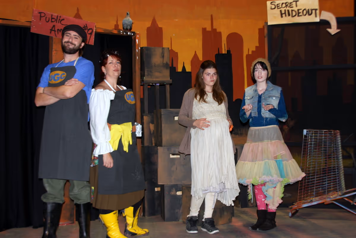 Bobby Strong (Chris Fleischman) and Penelope Pennywise (Rebecca Havely) guard the "Public Amenity" as other denizens stand near in a scene for "Urinetown" at Theatre 29!