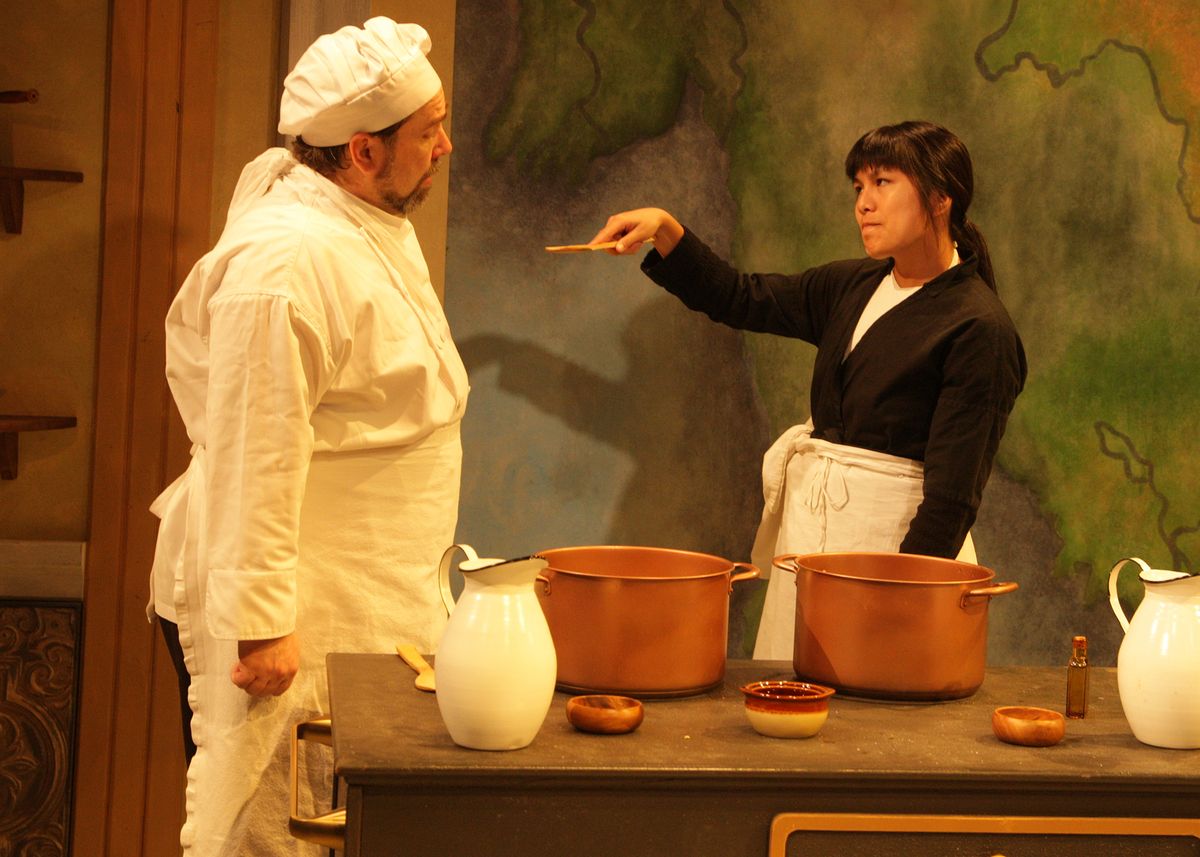 Casey Long as Guillaume and Hannah Mariah as Thúy in the rolling world premiere of "Colonialism is Terrible, But Phở is Delicious," playing March 31 - April 30, 2023 at Better Aitken theater arts Center on the Cripe Stage. Written by Dustin H. Chinn; Directed by Oánh Nguyễn. Photo by Doug Catiller, True Image Studio. 