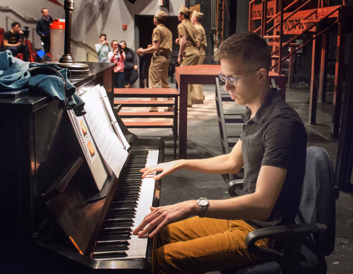 Musical Director Jordan Jones-Reese provided piano accompaniment as members of the cast of the Penn State Centre Stage production of 'Dogfight' rehearsed the song 'Some Kinda Time' on Mar. 18 at the Penn State Downtown Theatre. Jones-Reese is a second year M.F.A. candidate at Penn State in Music Direction for Musical Theatre. 'Dogfight' opens April 1 at the Penn State Downtown Theatre Center.  Image: Patrick Mansell