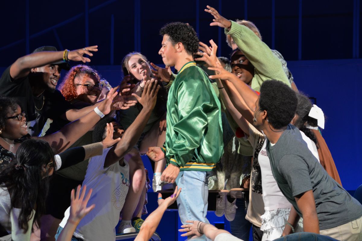 Anthony Cosme as Tommy Ross and the ensemble of Carrie: The Musical singing Do Me a Favor