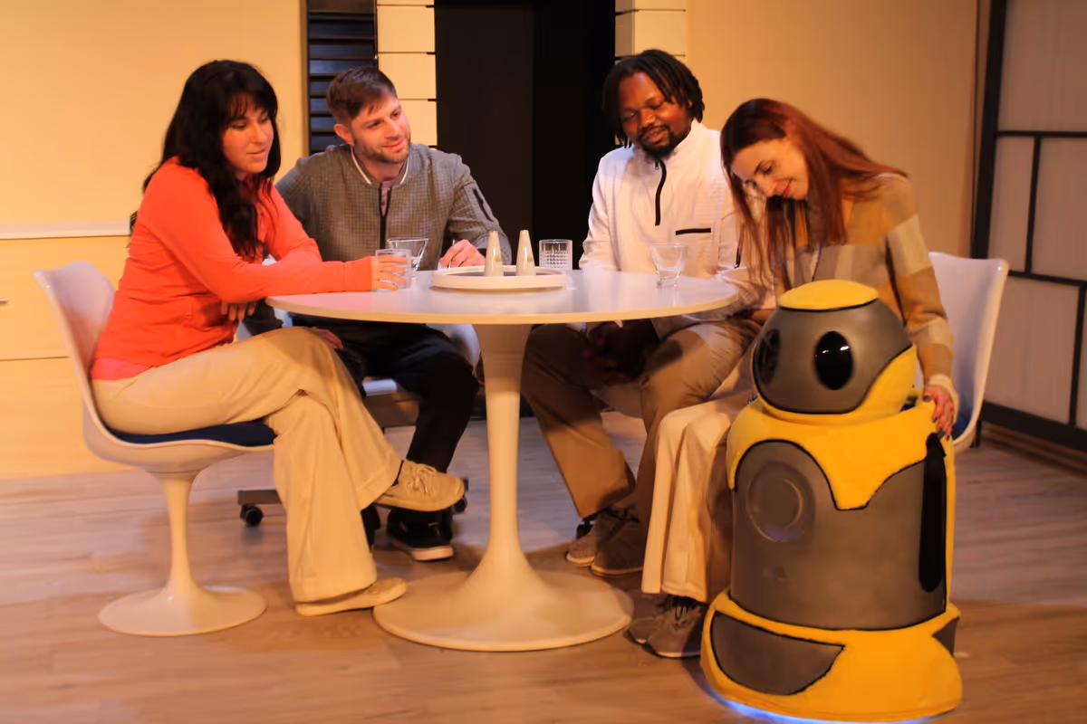 Carrie (Chloe Richter), Patrick (John Lopacki), Oliver (Jamil Long), and Anna (Caity Brown) all enjoying a friendly dinner with Arthur (Voiced by Scott Karlin and operated by Robert A. Norman).