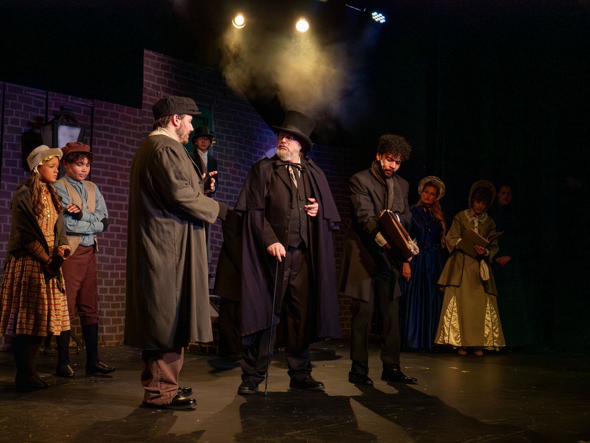 L TO R: Caroline V. as Ensemble, Teo P. as Ensemble, Andrew Neal as Ensemble, Darrell Meek as Scrooge, Christian No l as Bob Cratchitt.