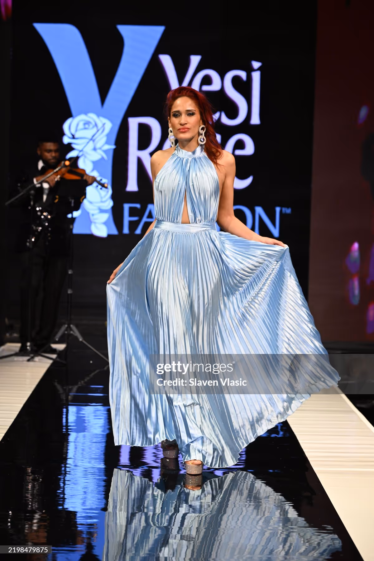 HiTechMODA Productions NYFW Season 13 - Yesi Rose Fashion NEW YORK, NEW YORK - FEBRUARY 08: Violinist Dr. Edward W. Hardy performs on stage while a model walks the runway wearing Yesi Rose Fashion du HiTechMODA Productions NYFW Season 13 - Yesi Rose Fashion NEW YORK, NEW YORK - FEBRUARY 08: Violinist Dr. Edward W. Hardy performs on stage while a model walks the runway wearing Yesi Rose Fashion du