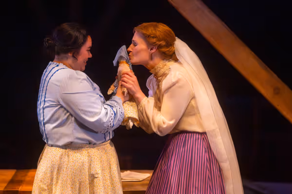 Meg (Amy Rene Byrne) says farewell to her childhood and family home, as represented by Beth's (Kimie Muroya) doll on her wedding day (r-l: Amy Rene Byrne, Kimie Muroya).  20