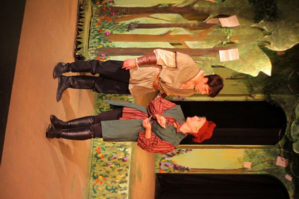 Even a fool like Touchstone (Ken Knight) can find love in the forest with Audrey (Andrea Stradling) as Jaques (Jonah Goger) eavesdrops. 2