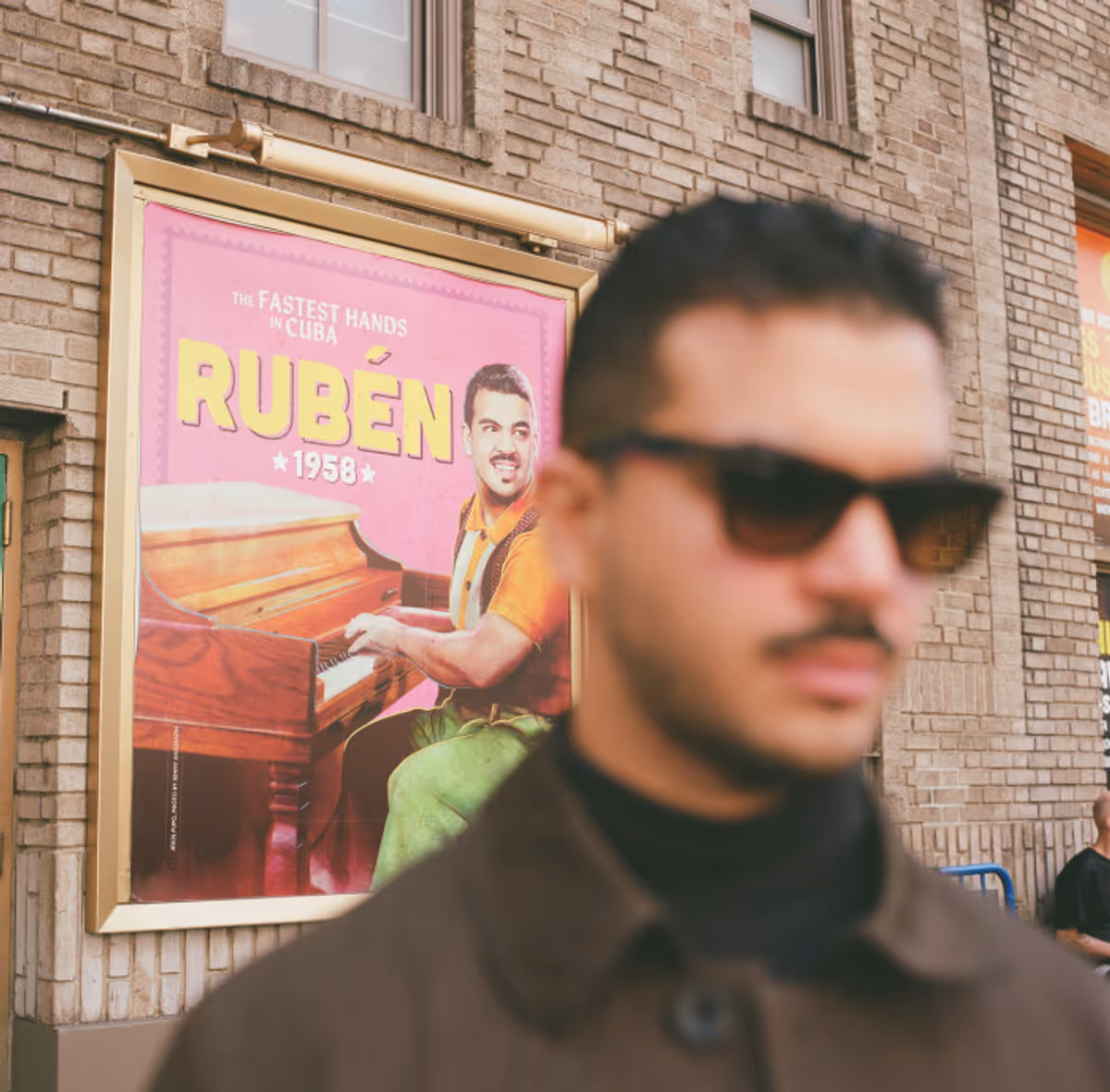 Jesus Pupo beside the Young Ruben character poster outside the Gerald Schoenfeld… Photo
