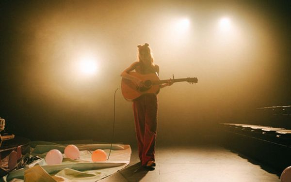 Ally Morgan sits on a raised platform surrounded by ecclectic furniture and her instruments. Image by Cameron Grant, Parenthesy 3