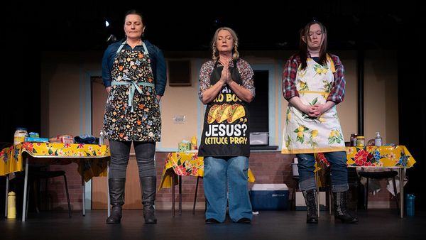 Claudia (Devin Rodger), Joyce (Brynne Garman), and Hannah (Shawna Petty), come together in the fellowship hall of a Presbyterian Church to make sandwiches for those who have been affected by a once-in 1
