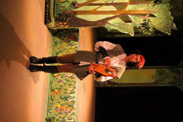 Even a fool like Touchstone (Ken Knight) can find love in the forest with Audrey (Andrea Stradling) as Jaques (Jonah Goger) eavesdrops. 4