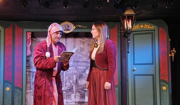 Ebenezer Scrooge and Bobbi Ann Cratchit discuss the merits of Charles Dickens'' book in THE THREE SCROOGES at Curtain Call...a madcap musical romp playing in The Dressing Room Theatre.    (Michael Pela 3