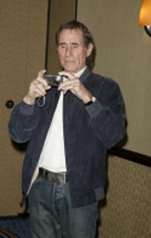 Jim Dale turns the tables on the assembled photogs... Photo
