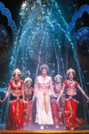 Sandra Allen and ensemble dance within an enormous fountain that drenches the stage Photo