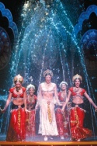 Sandra Allen and ensemble dance within an enormous fountain that drenches the stage Photo