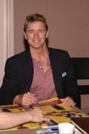 John Schneider looks up from autographing posters to give us a quick smile Photo