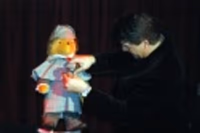 Bryan Batt buttoning the coat of Baker Street Sherlock Holmes Bear Photo