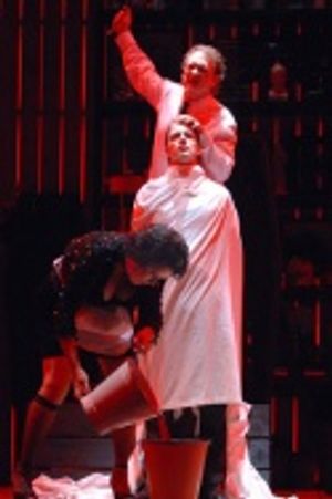 Mrs. Lovett (Judy Kaye) retrieves a bucket of blood as Sweeney Todd (David Hess) offe Photo