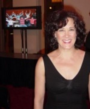 Karen Ziemba, a past recipient of the Beacon Award, stands in front of a screen displ Photo