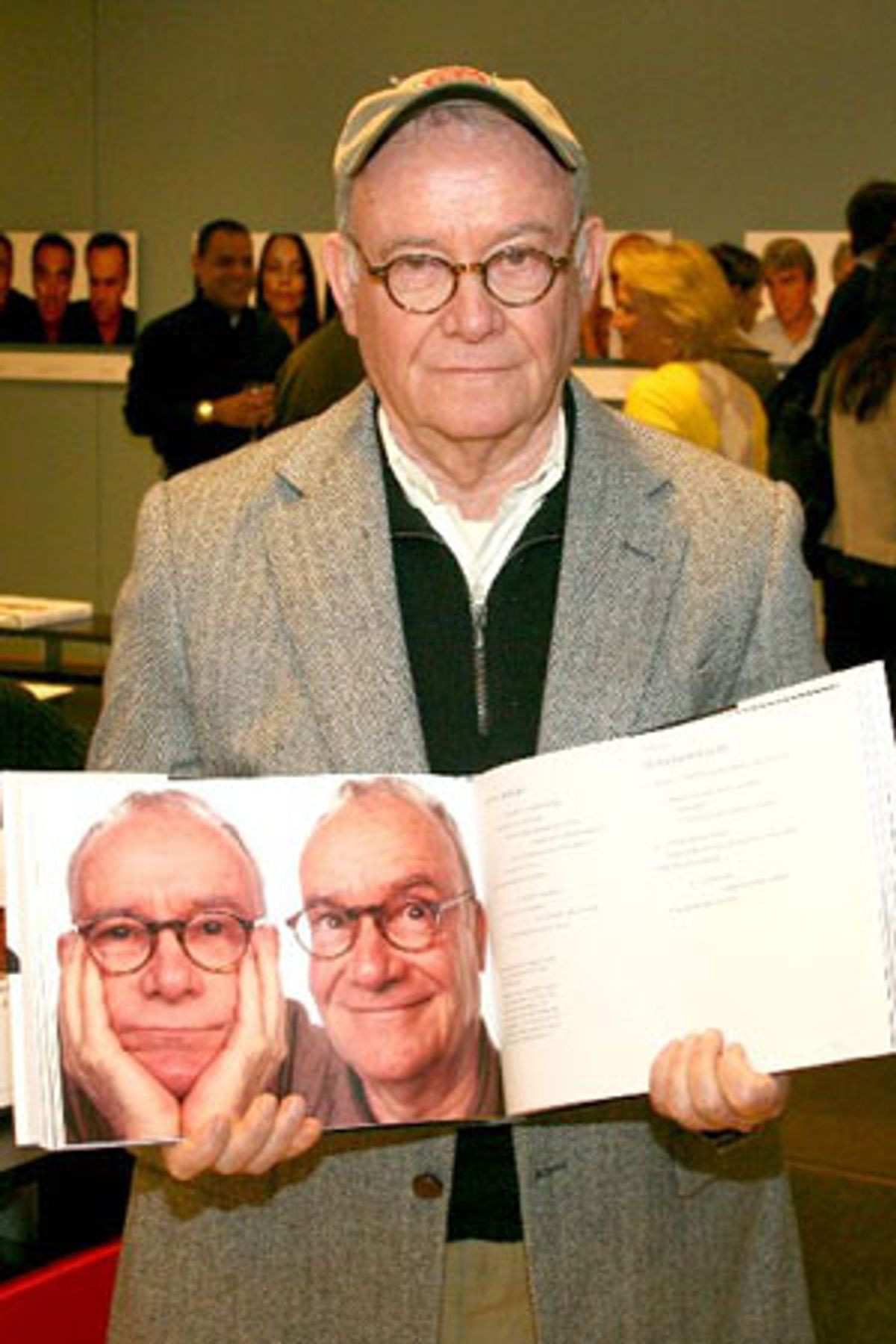 Buck Henry displaying his photos in a book at 