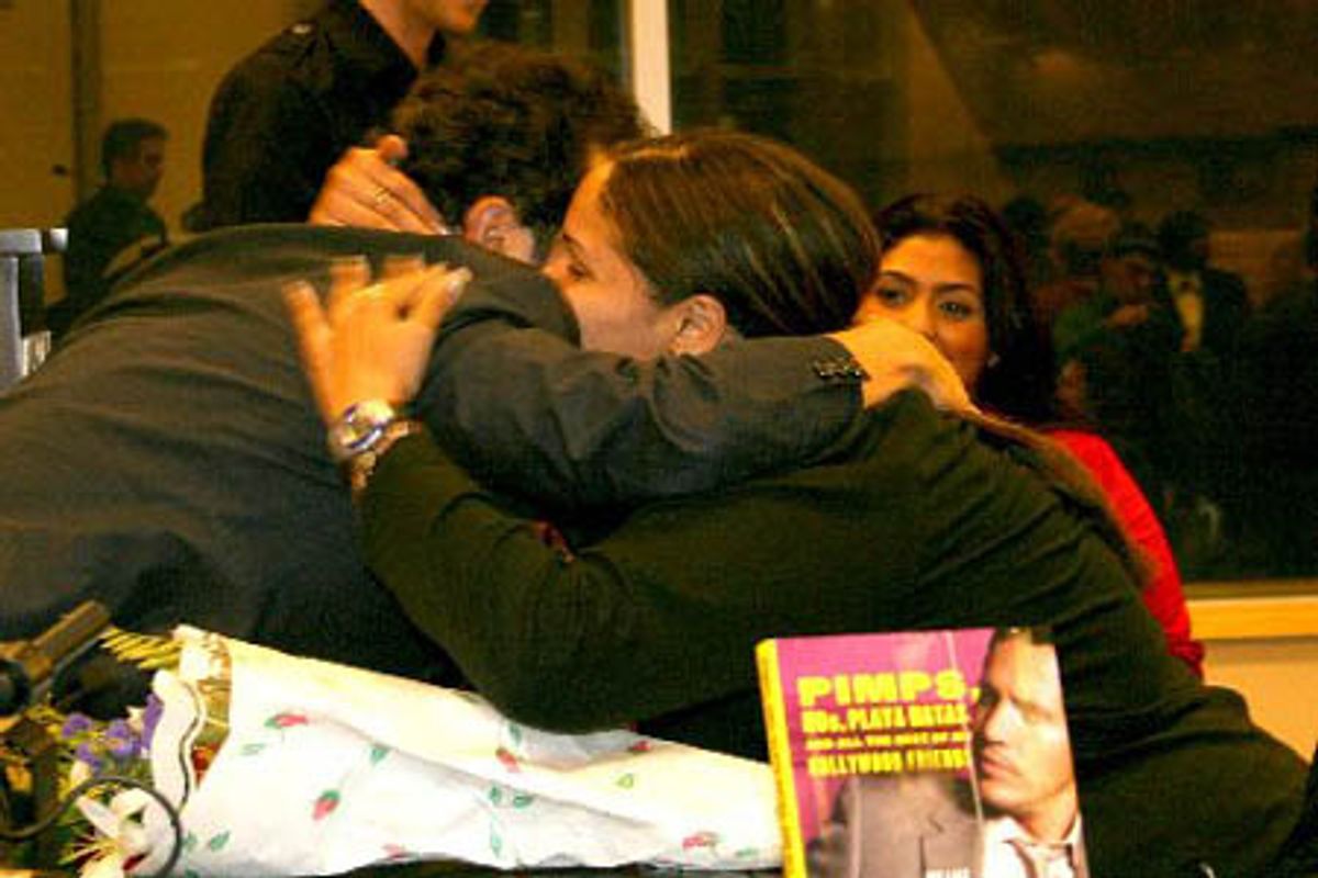 John Leguizamo hugs a fan, who has presented him with flowers at 