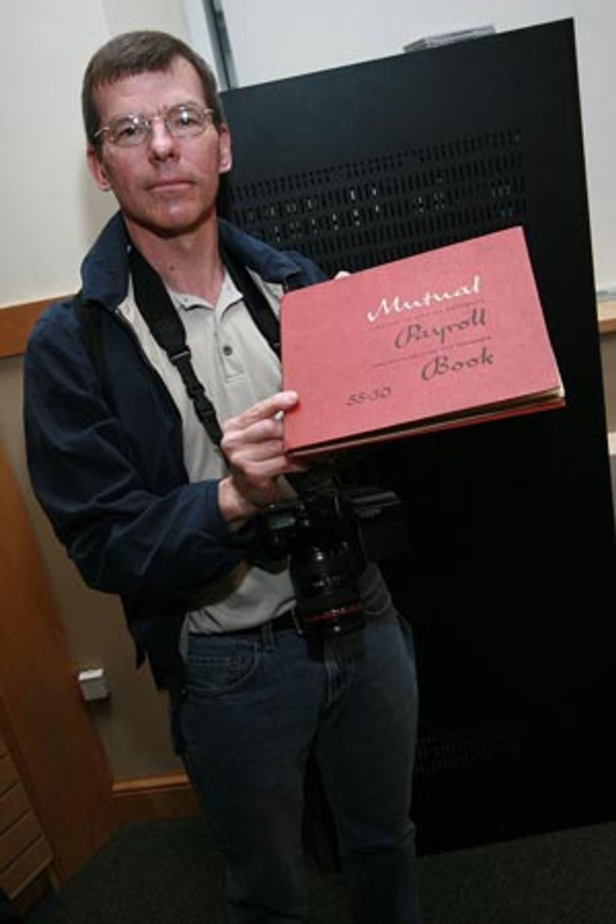 Bill Schroeder with a 1963 payroll ledger from the original production at 