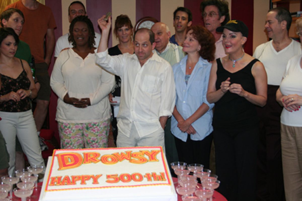 Cast member Jason Kravits (center) plays a voice mail message from Bob Martin congratulating the cast on their 500th. performance at 