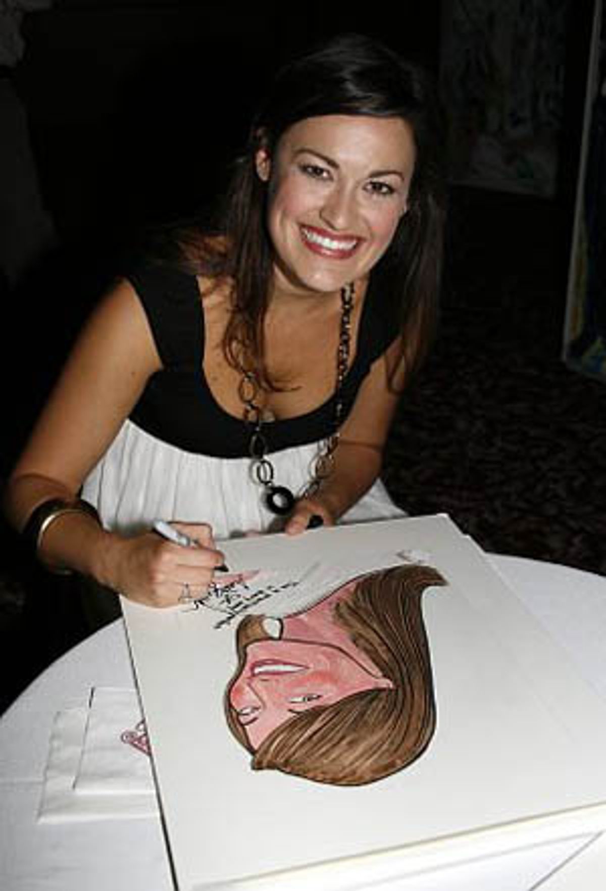 Ashley Brown signs her caricature at 