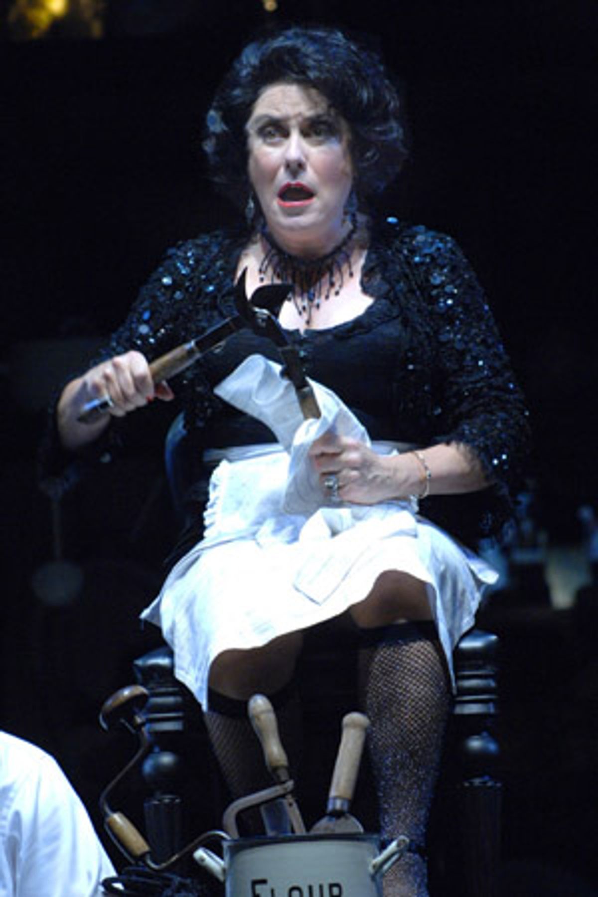 Mrs. Lovett (Judy Kaye) cleans up after a long day of baking meat pies at 