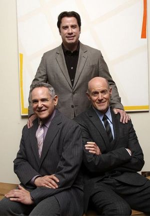 John Travolta with (seated l-r) Craig Zadan and Neil Meron Photo