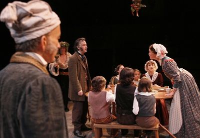 David Pichette as Scrooge, Richard Ziman as Spirit #2 and the cast as the Cratchits Photo