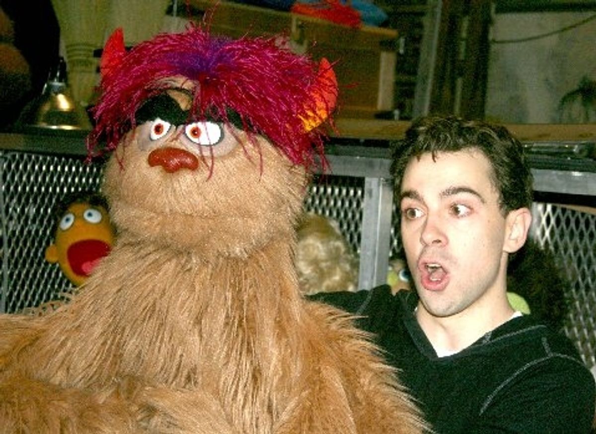 Robert McClure demonstrates puppet handling backstage after the show with Trekkie Monster at 