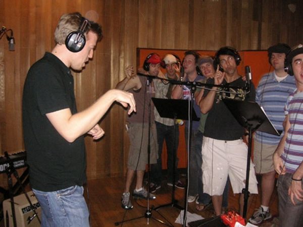 Chris Fenwick conducts the cast of Grease Photo