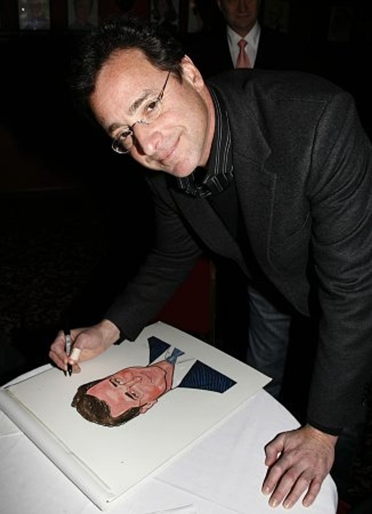 Bob Saget autographs his caricature
 at 