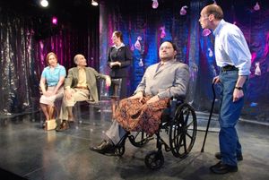 Orville Mendoza (in wheelchair) and John Daggett (standing) as Doug; background, l-r: Photo