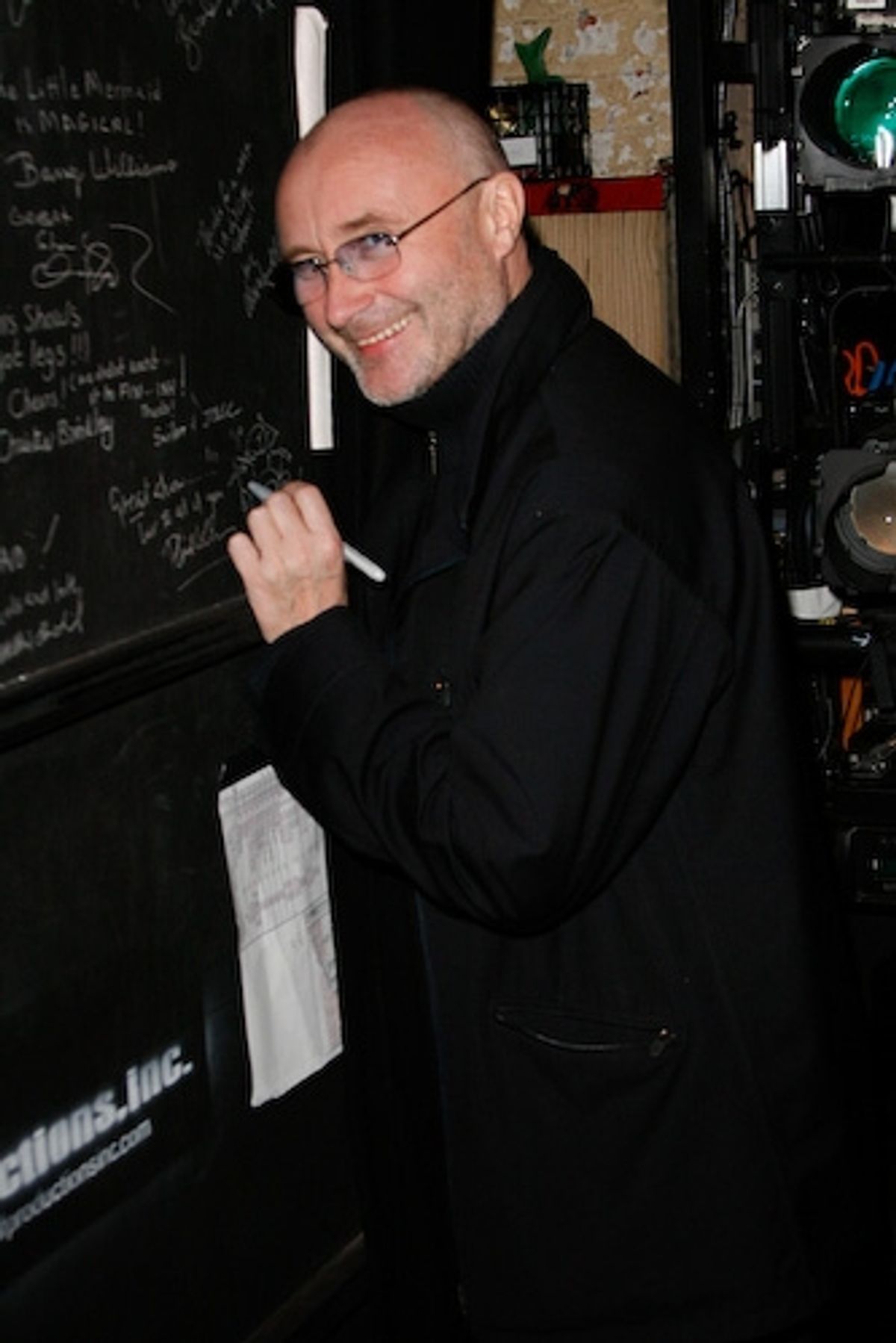 Phil Collins signs the cast wall. at 