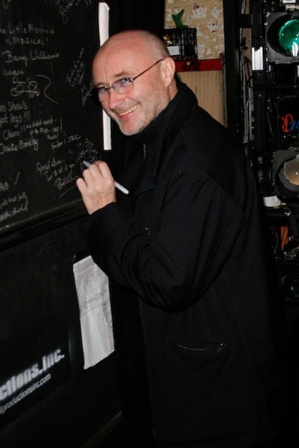 Phil Collins signs the cast wall. Photo