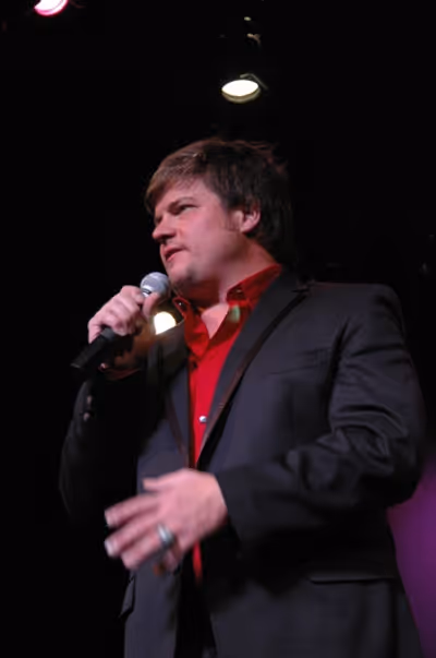 Rob Evan bringing the cast on for the final number Photo