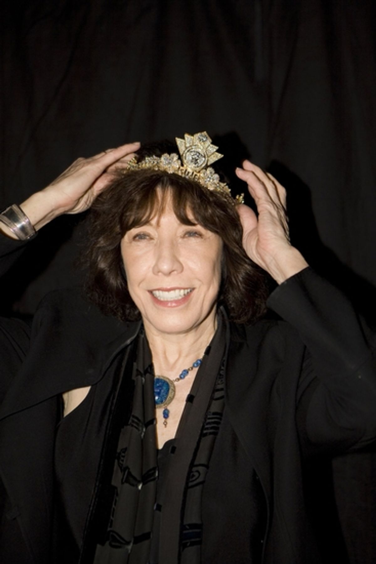 Lily Tomlin tries on the Versace Tiara for a good cause at 