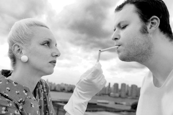 Angie Atkinson lights Doug Sharf's cigarette as Jo and Ant Knee, after escaping the J Photo
