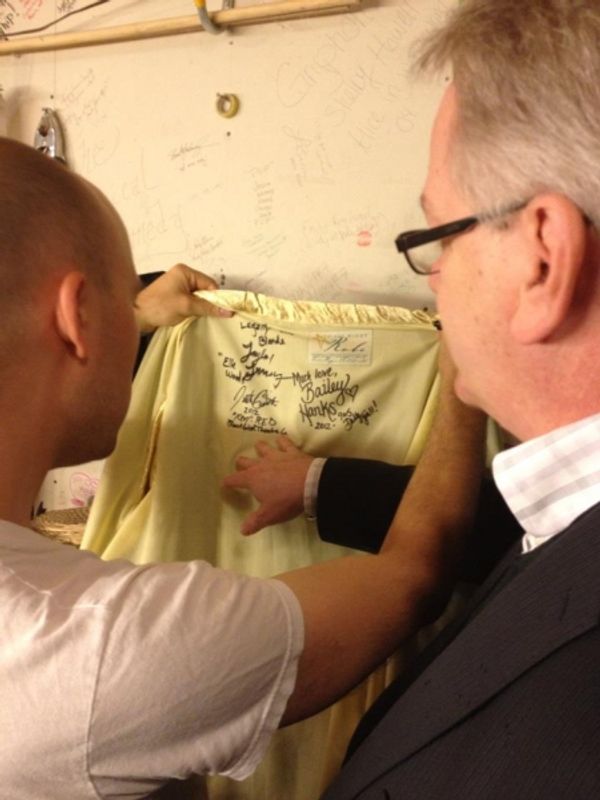 Paul Cook reads the autographs on the First Night Robe Photo