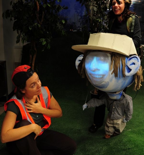 Kalle Macrides as Lia and Puppeteer Caroline Tamas as Big Headed Toddler video puppet Photo